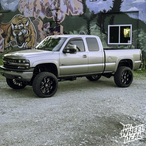 22x12" -44mm Black Milled Hostile Predator wheels with 33x12.5R22LT Nitto Ridge Grappler tires on a 2002 Chevy Silverado 2500